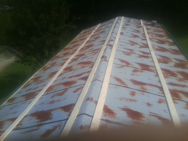 Rusted metal roof panels with new wood purlins before replacement — Storm Damage Roof Repair in Minco by Roofing Brothers